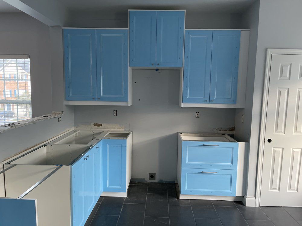A kitchen with blue cabinets and white counter tops