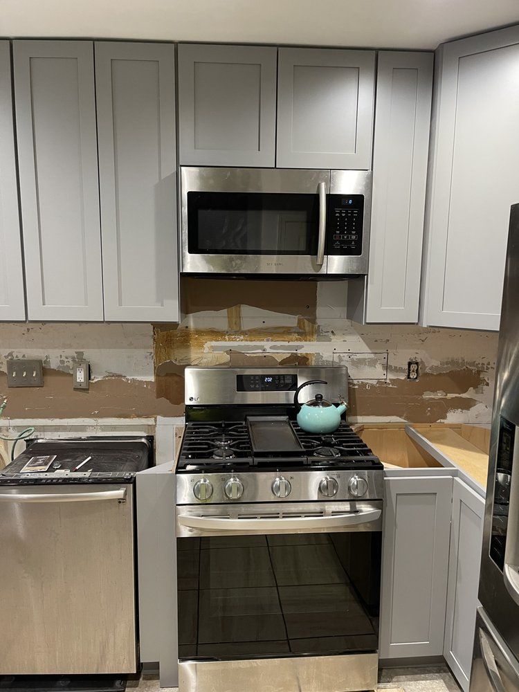 A kitchen with stainless steel appliances and gray cabinets