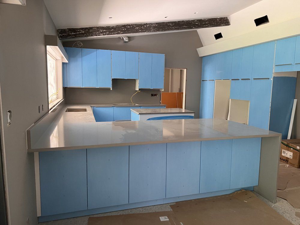 A kitchen with blue cabinets and white counter tops