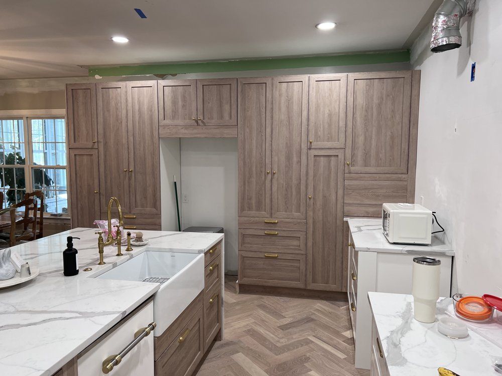 A kitchen with wooden cabinets and white counter tops is being remodeled.