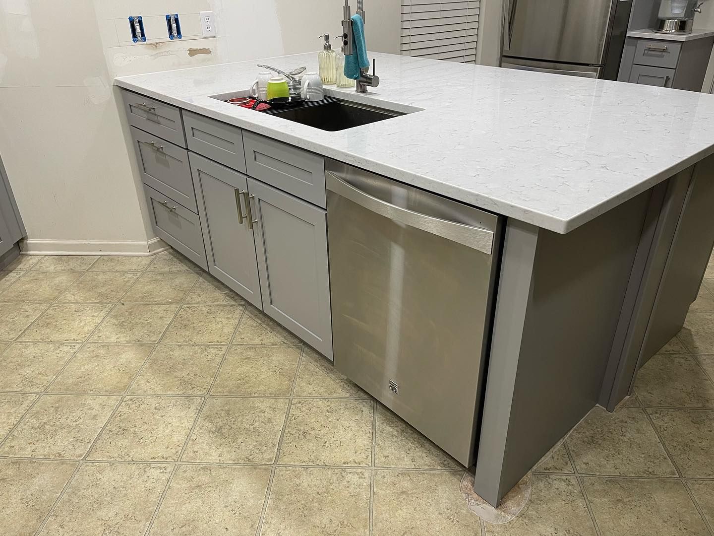 A kitchen with a stainless steel dishwasher and a sink.