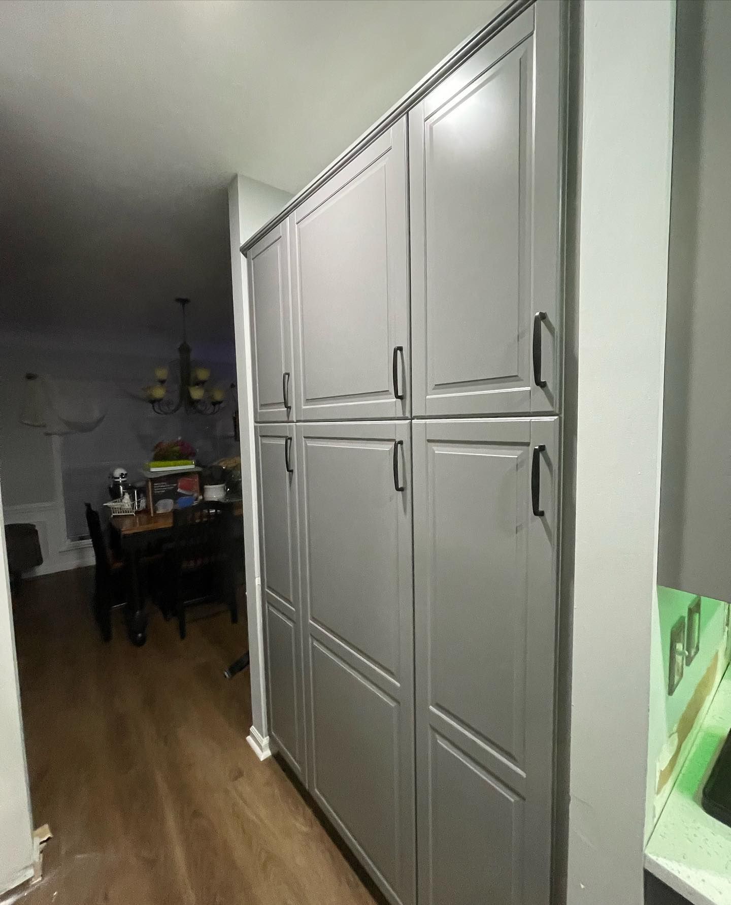 A kitchen with a lot of cabinets and a dining room in the background.