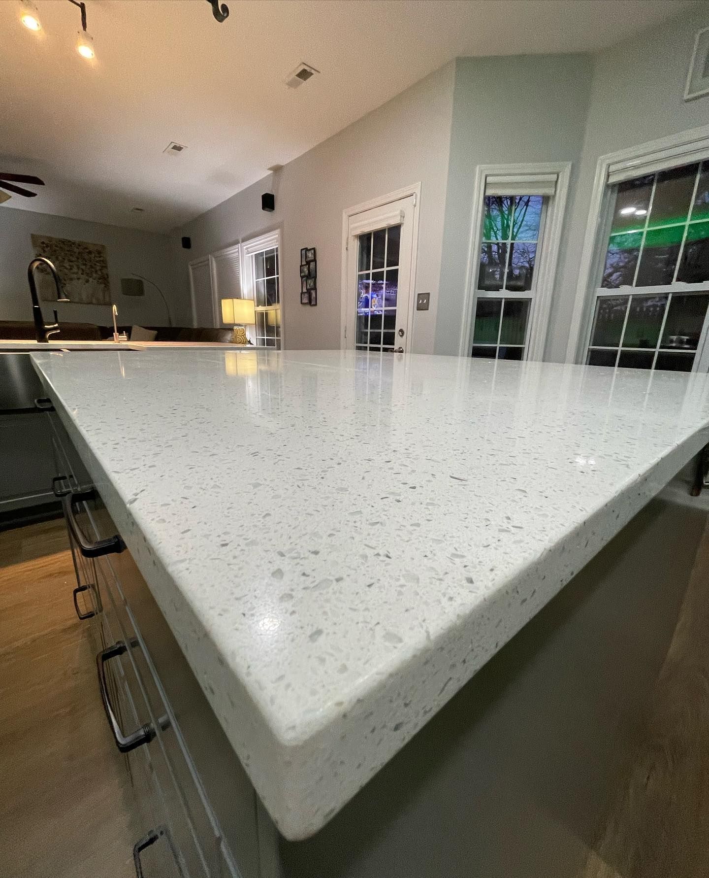 A kitchen with a large white counter top and a sink.