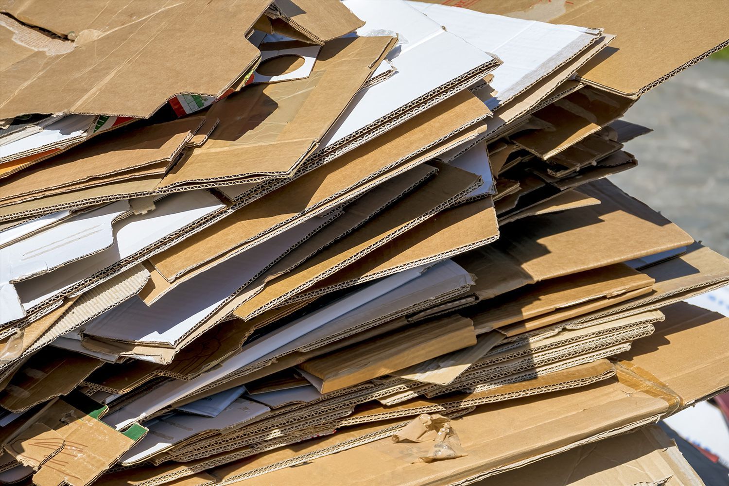 Flattened cardboard recycling pile ready for collection to reduce waste and environmental impact.