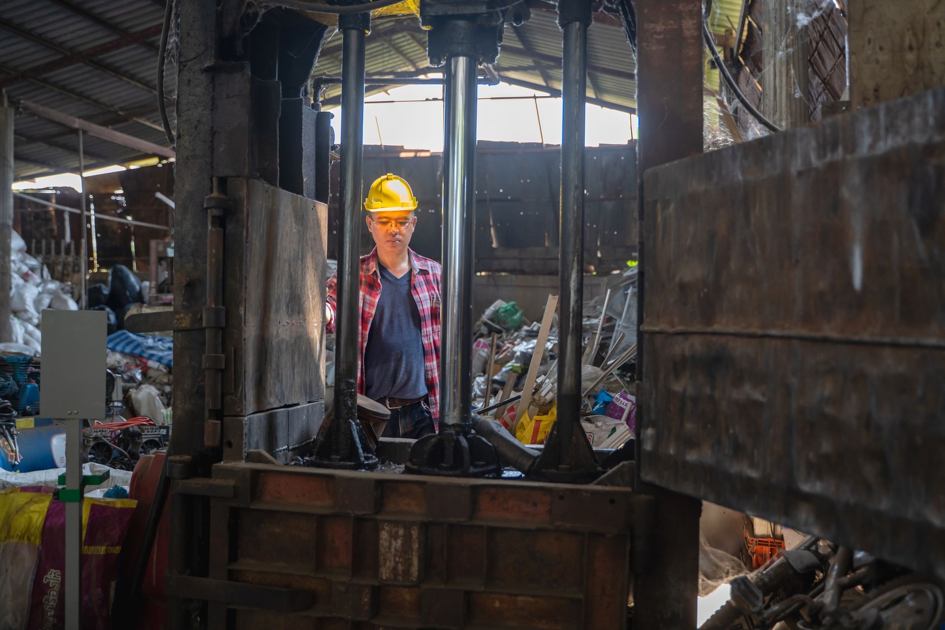 Male staff controls the separation of recyclables at a metal recycling facility. Male staff controls the separation of recyclables at a metal recycling facility.