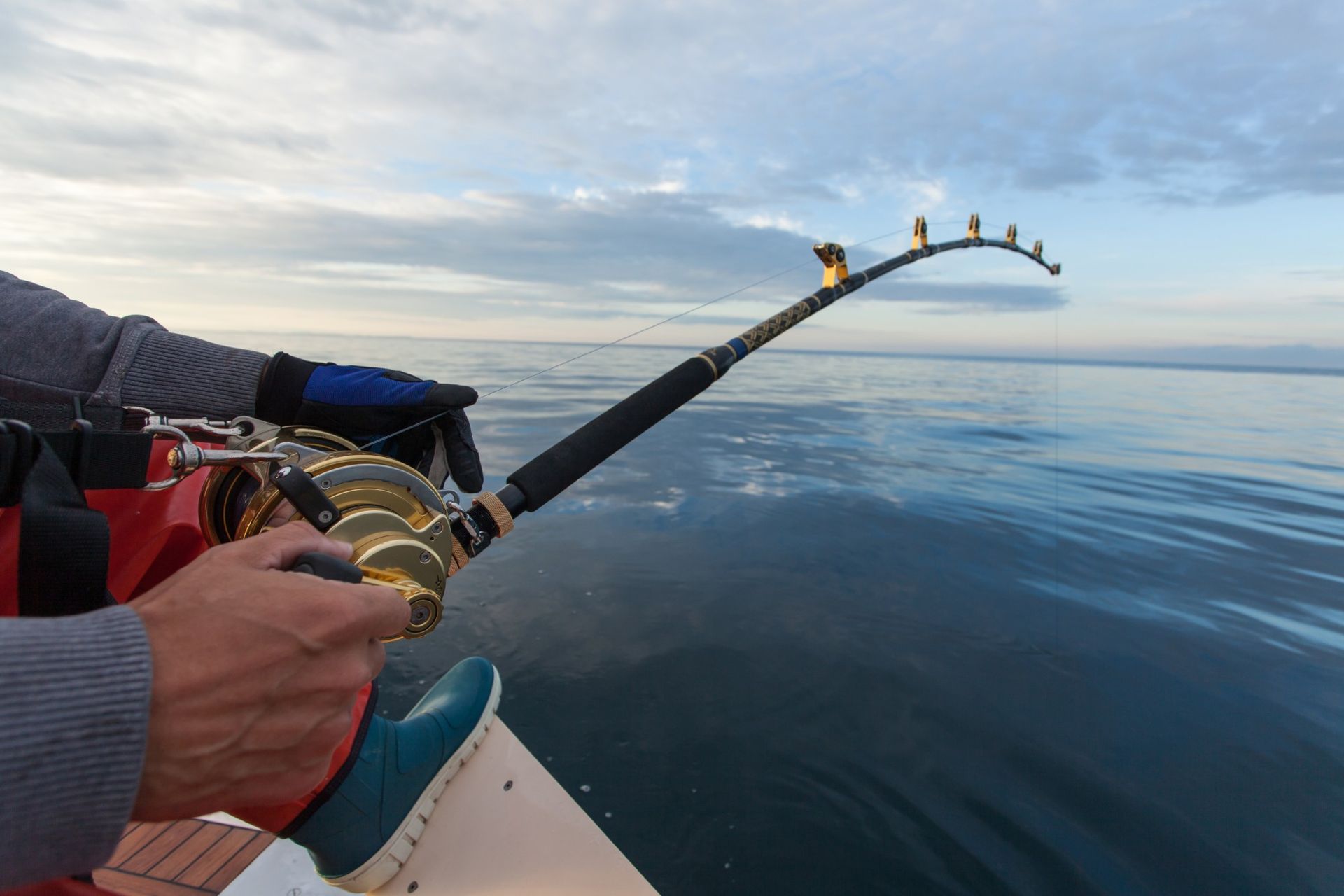 A person is fishing on a boat in the ocean.