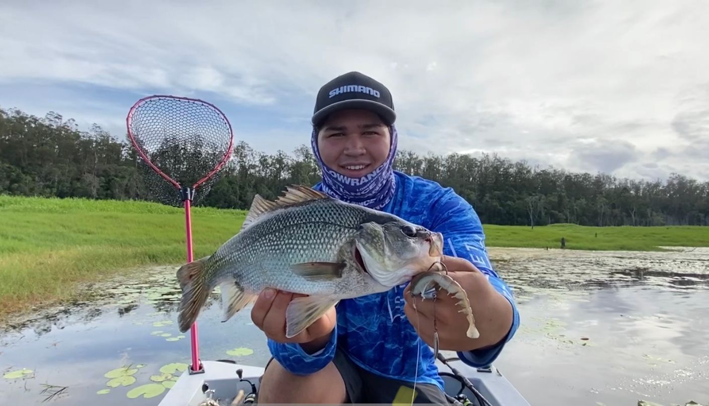 A man is holding a large fish in his hands while sitting on a boat.