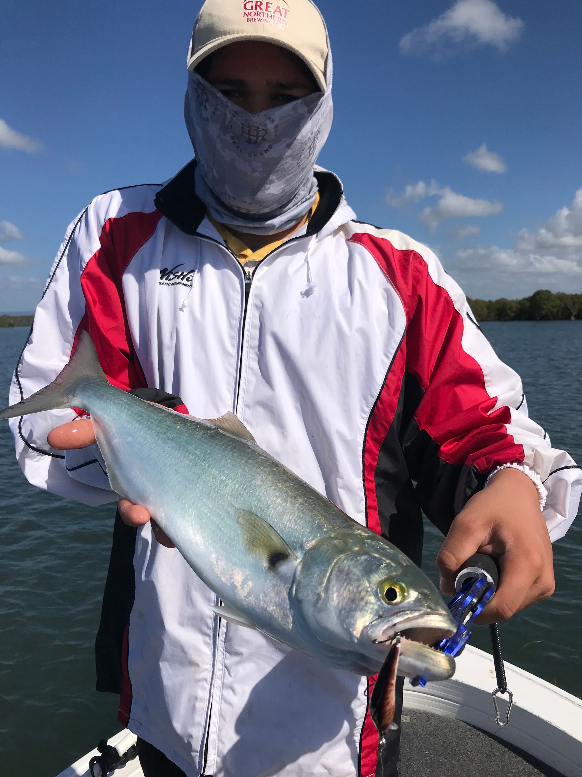 A man is holding a fish in his hands on a boat.