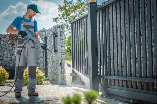 Professional power washer cleaning fences