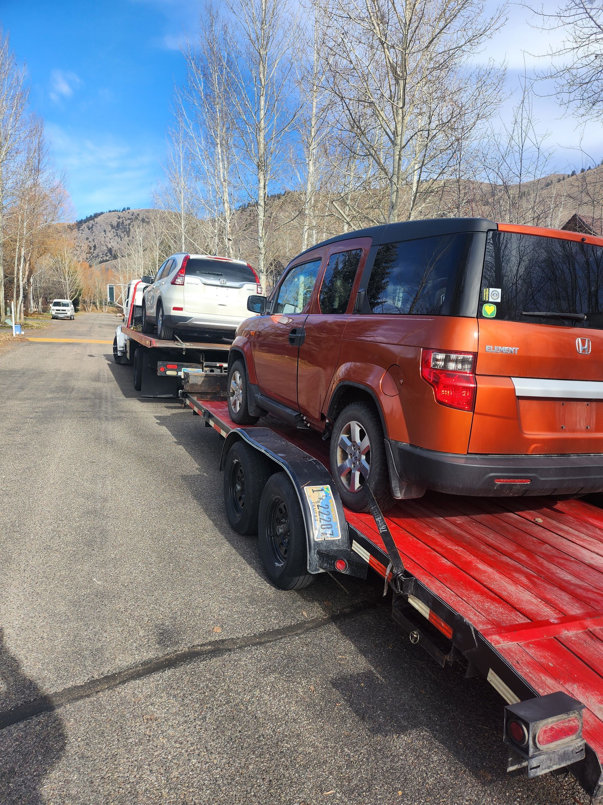 A car is being towed by a tow truck on a trailer.