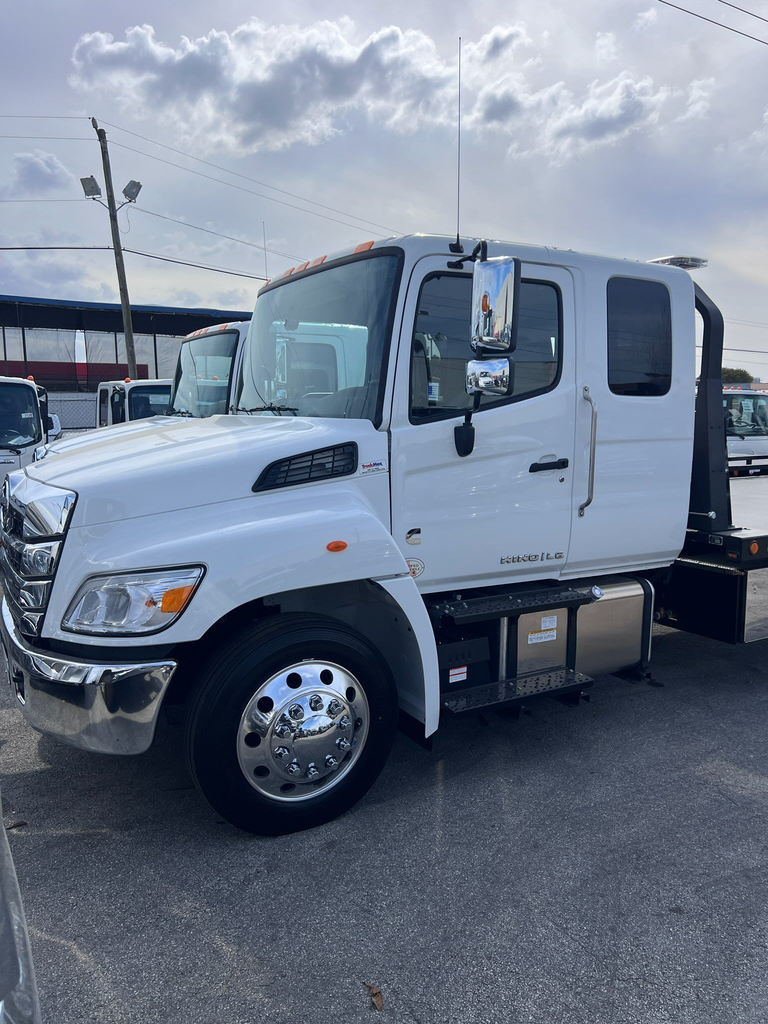 A white tow truck is parked in a parking lot.