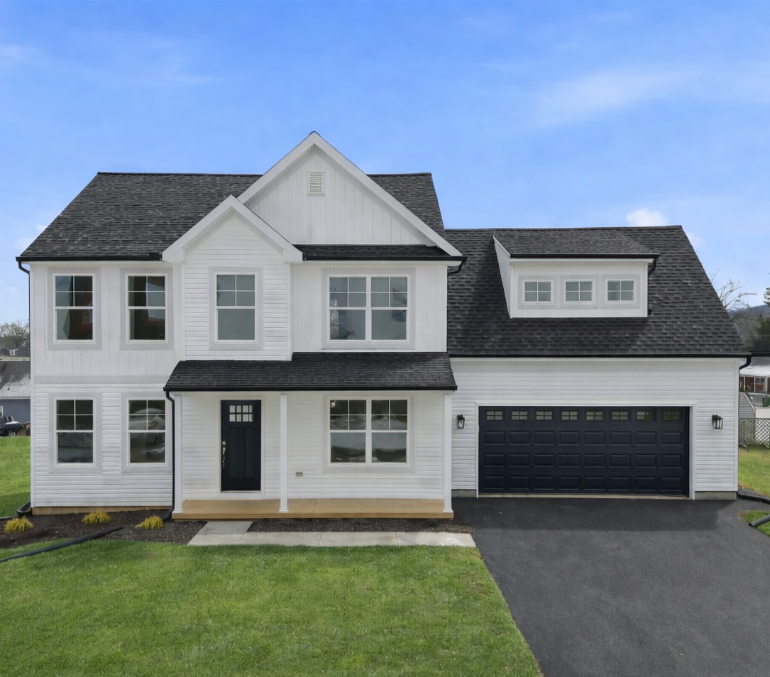 Two-story white house with black roof, front porch, and attached two-car garage