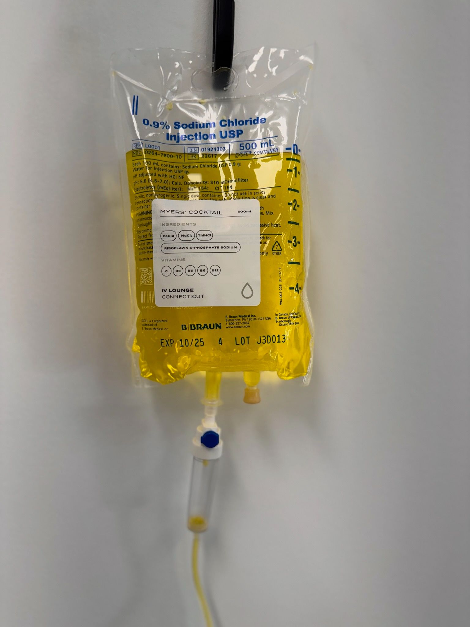 Yellow IV bag hanging, connected to tubing with a flow regulator.
