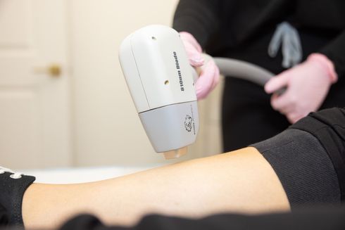 A woman is getting a laser hair removal treatment on her leg.