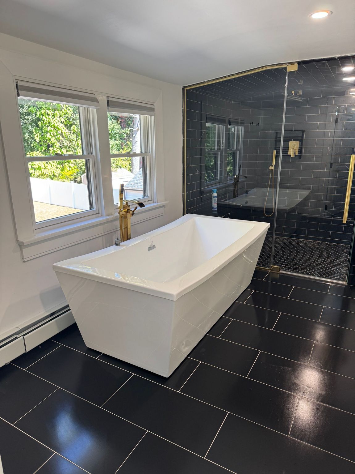 Spacious, modern living room with large windows, beige sectional sofa, and light wood accents.