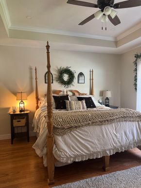 Man vacuuming a cream-colored rug in a well-lit living room, using a black and gray vacuum cleaner.