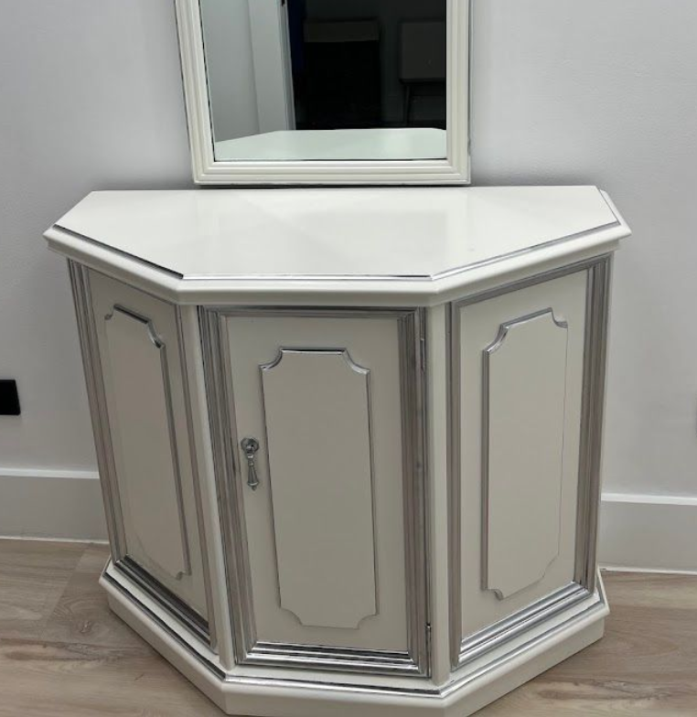 White octagonal vanity cabinet with mirror against a light gray wall