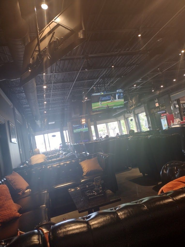 A restaurant with a lot of furniture and a television on the wall.