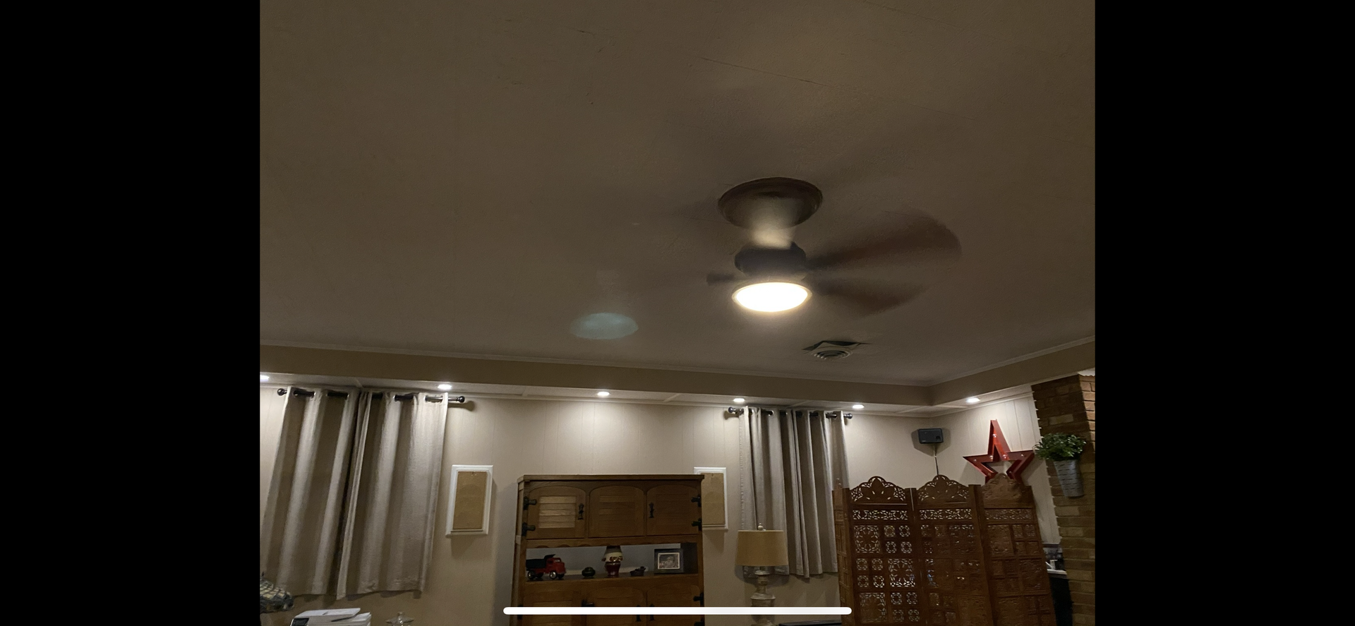 Ceiling fan with light fixture, interior view of a room with curtains and recessed lighting.