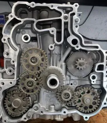 A close up of a motorcycle engine with gears on it