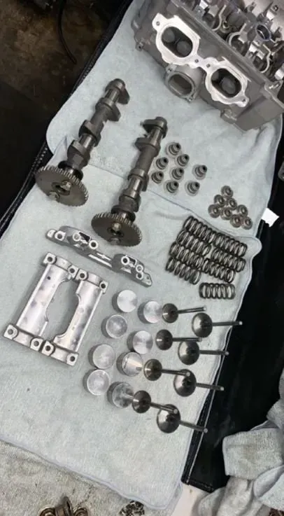 A bunch of metal parts are laying on a towel on a table.