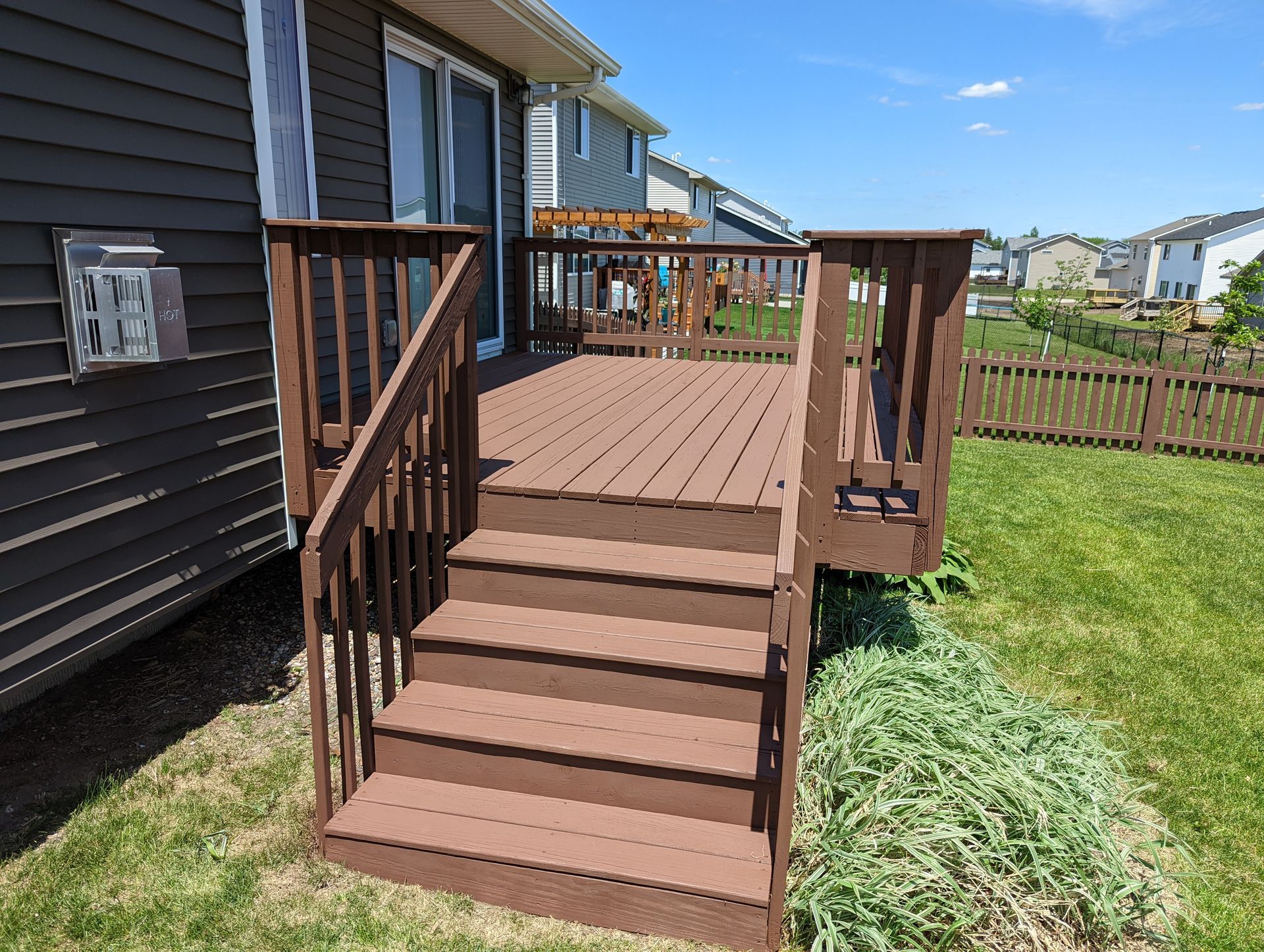 Deck staining and fence painting during summer maintenance