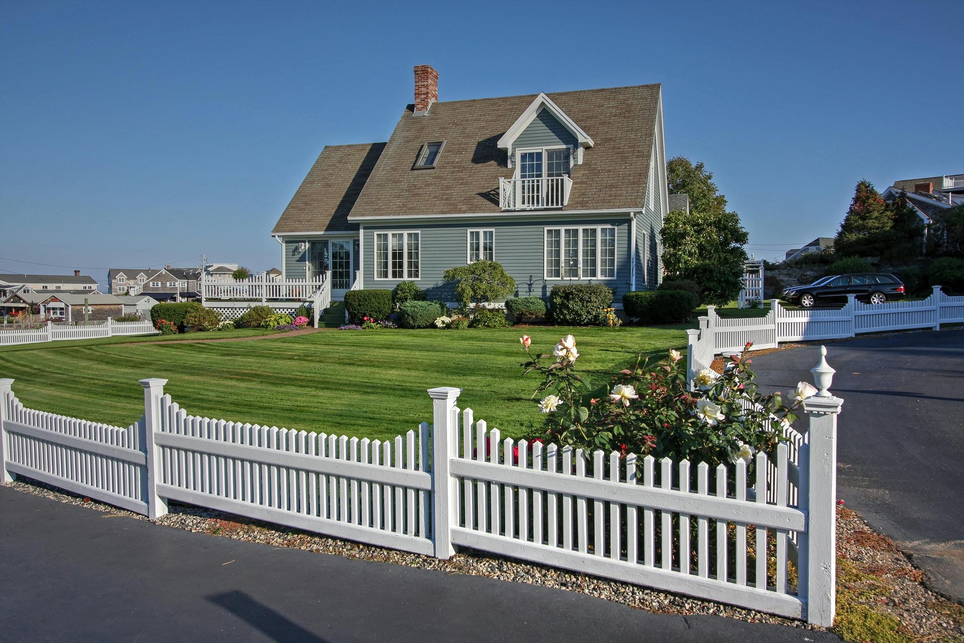 Freshly painted white picket fence around a well maintained yard