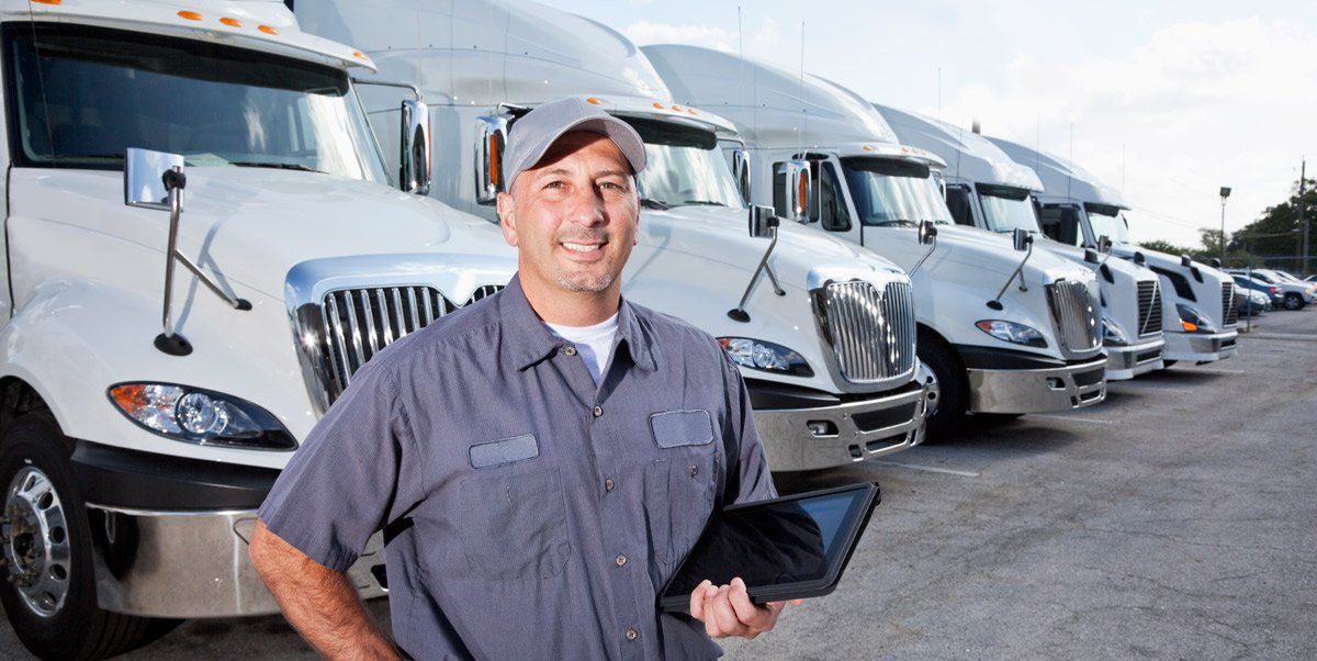 man standing in front of line of trucks