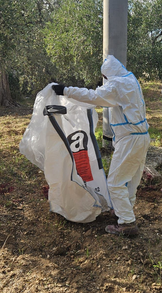 Cucina e sala da pranzo con pareti in mattoni a vista, tavolo bianco e sedie grigie. Finestre luminose e lampade a sospensione.