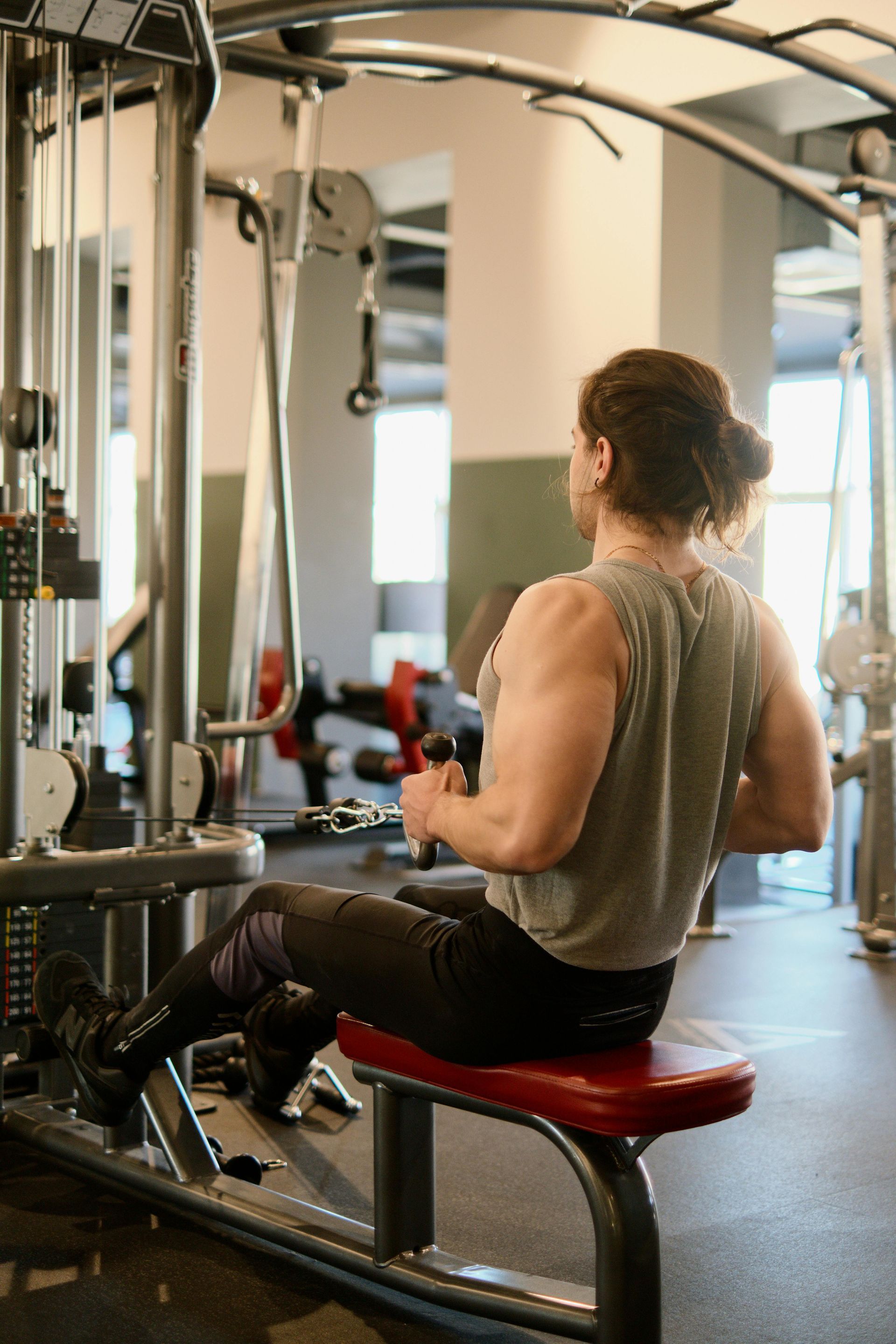 Person doing a seated cable row exercise at a gym.