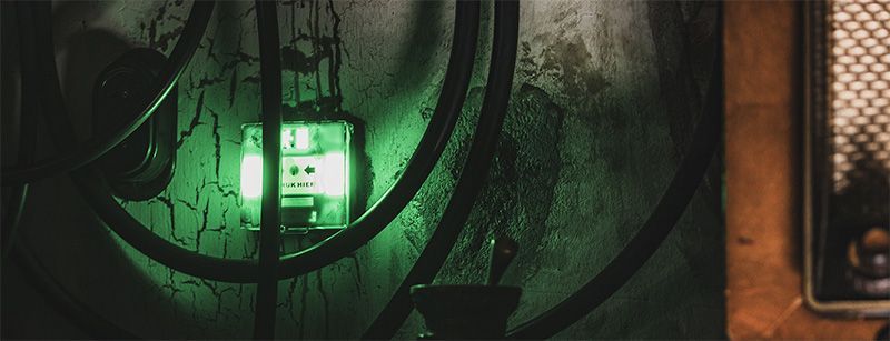 Een groen licht schijnt op een donkere muur.