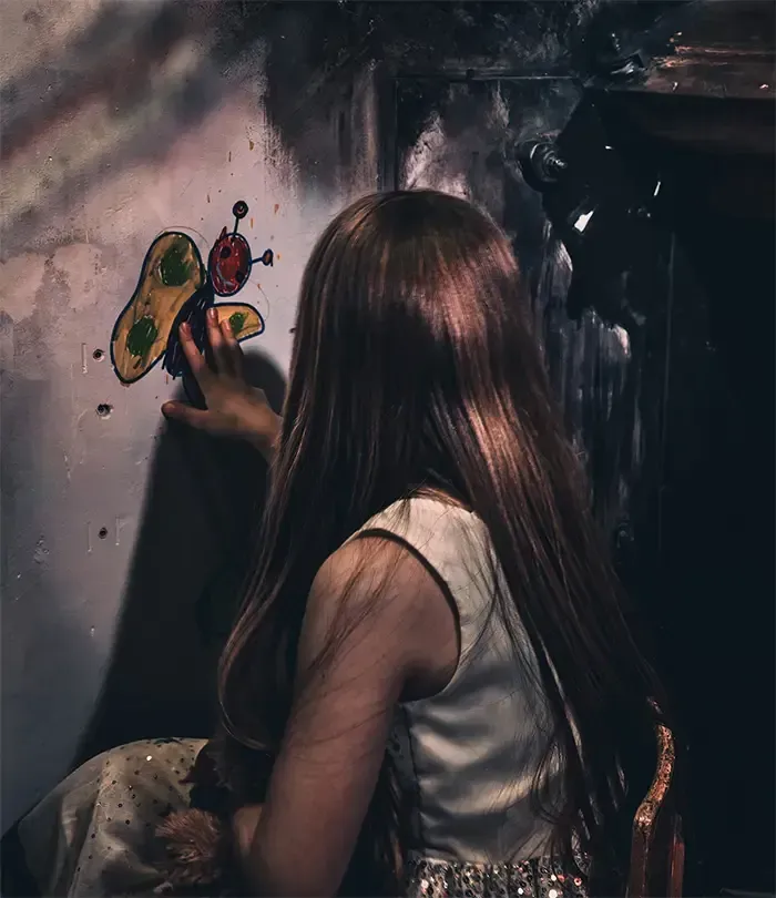 Een meisje met lang haar houdt een vlinder in haar hand