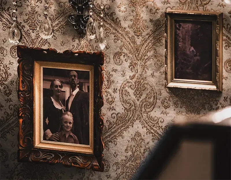 Aan de muur hangen twee ingelijste foto's van het gezin schillinger.