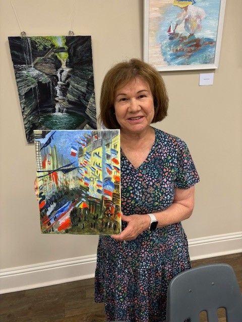 A woman is holding a painting in her hands in a room.