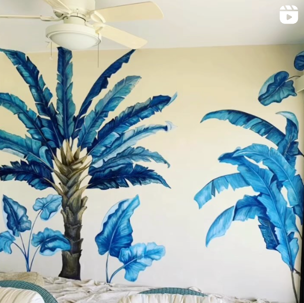A painting of palm trees on a wall with a ceiling fan
