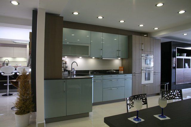 A showroom modern kitchen with turquoise cabinets and wooden exterior bringing class and elegance to the kitchen.