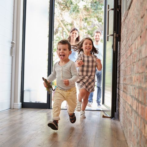 Excited Children Arriving Home With Parents