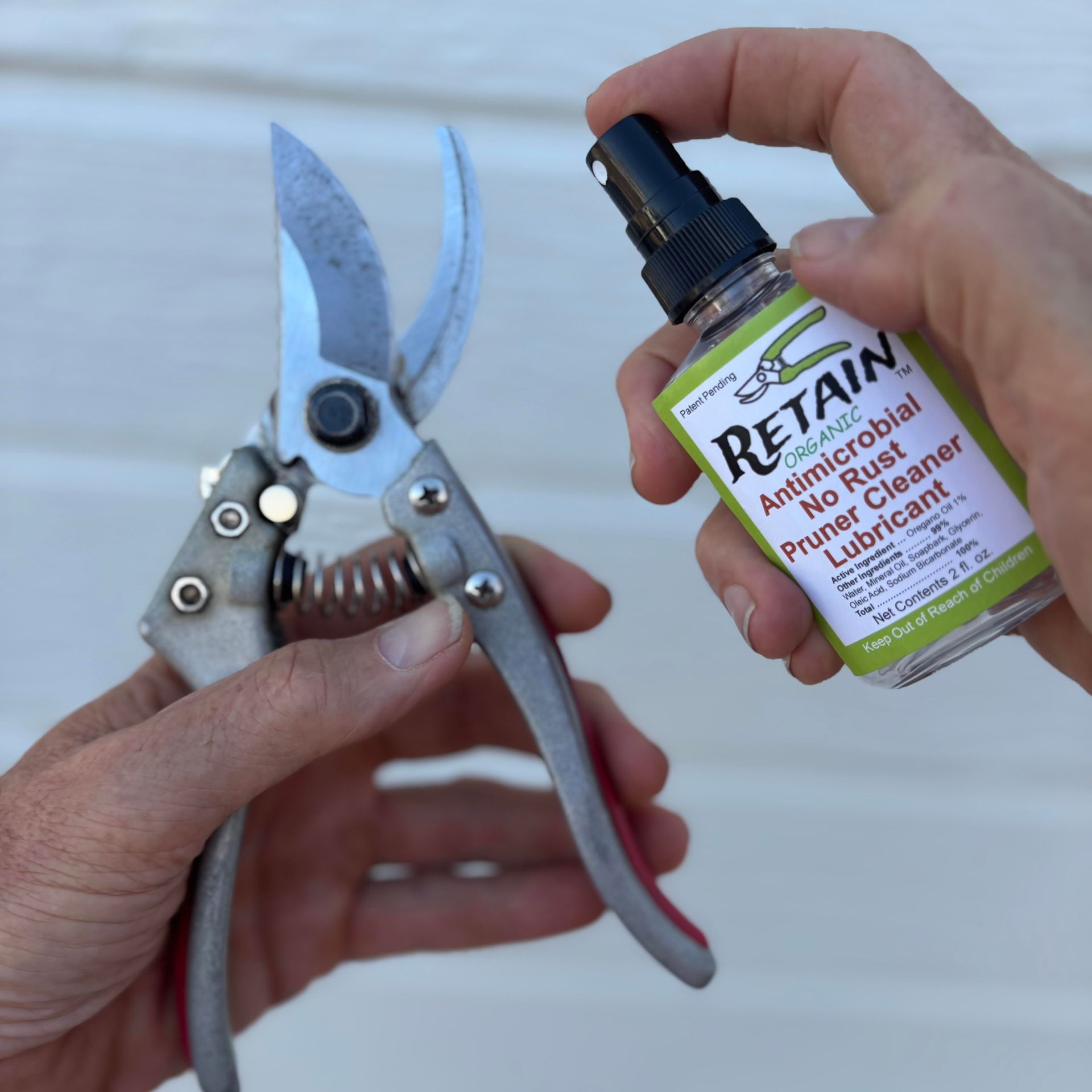 Person spraying pruner with antimicrobial cleaner.
