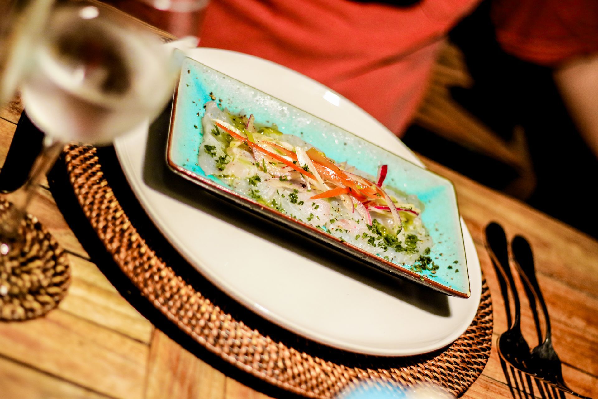 A plate of food on a table with a glass of wine