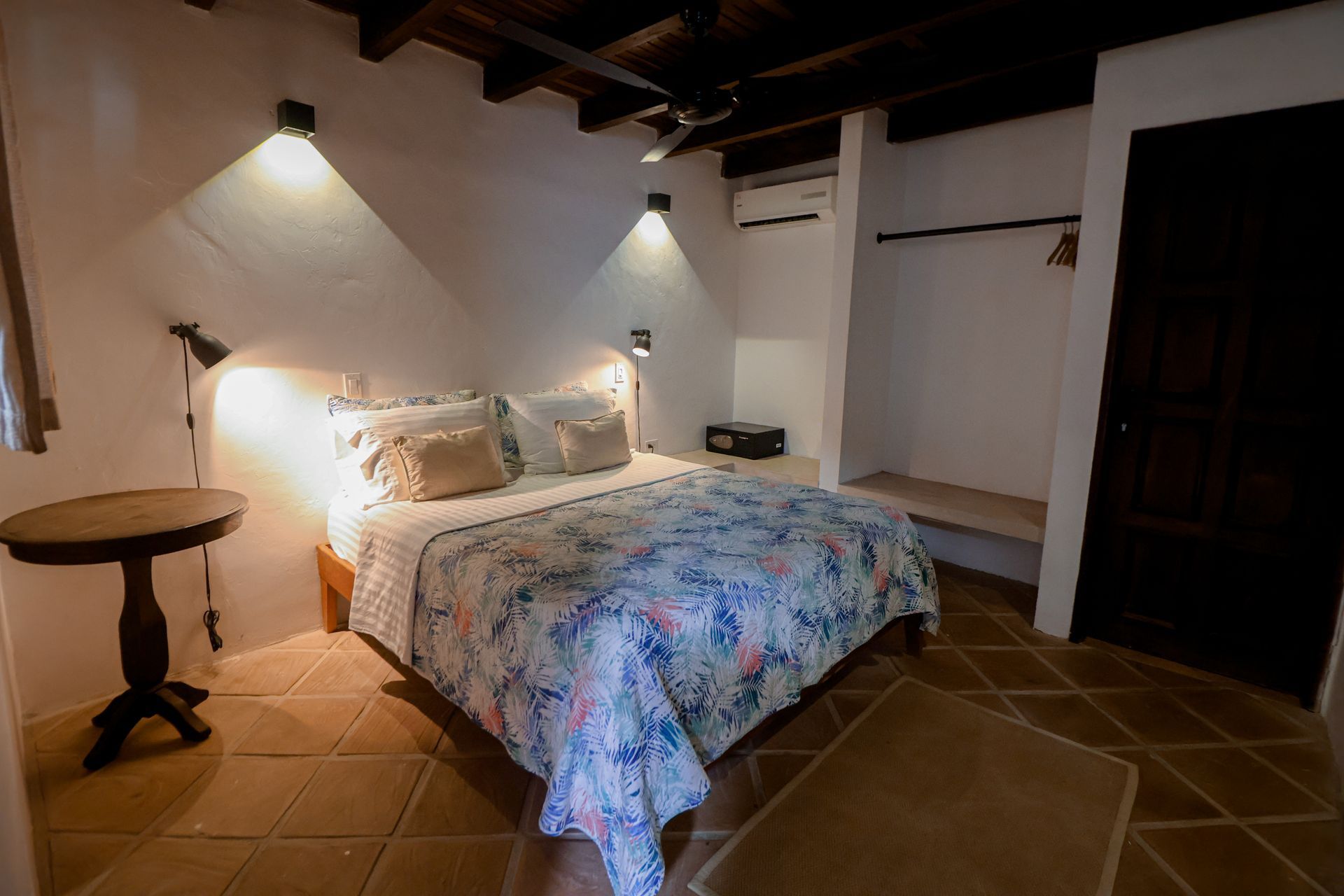 A bedroom with a large bed and a small table.