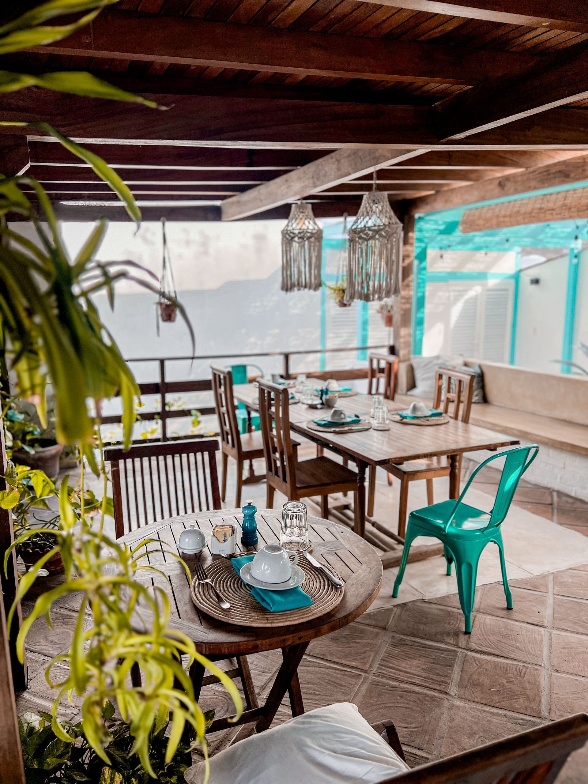 A dining room with tables and chairs and a view of the ocean.
