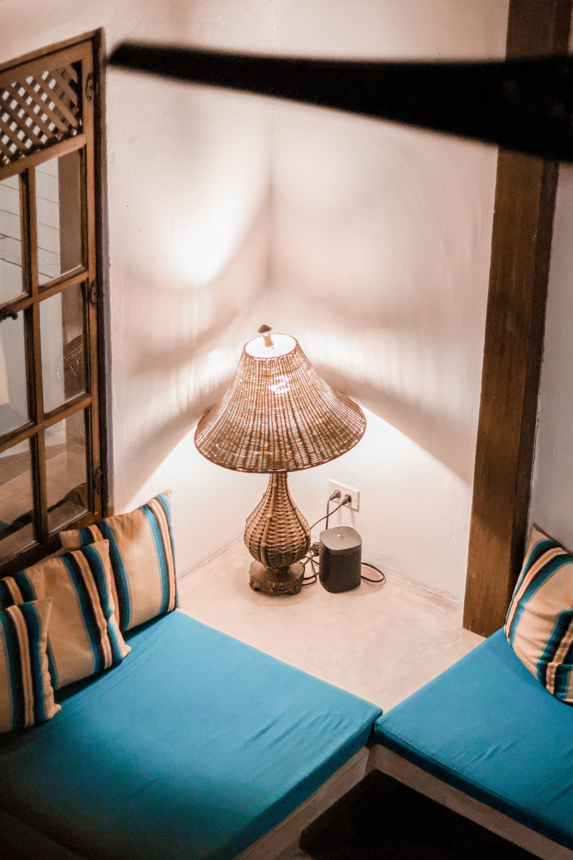 A living room with two blue couches and a lamp