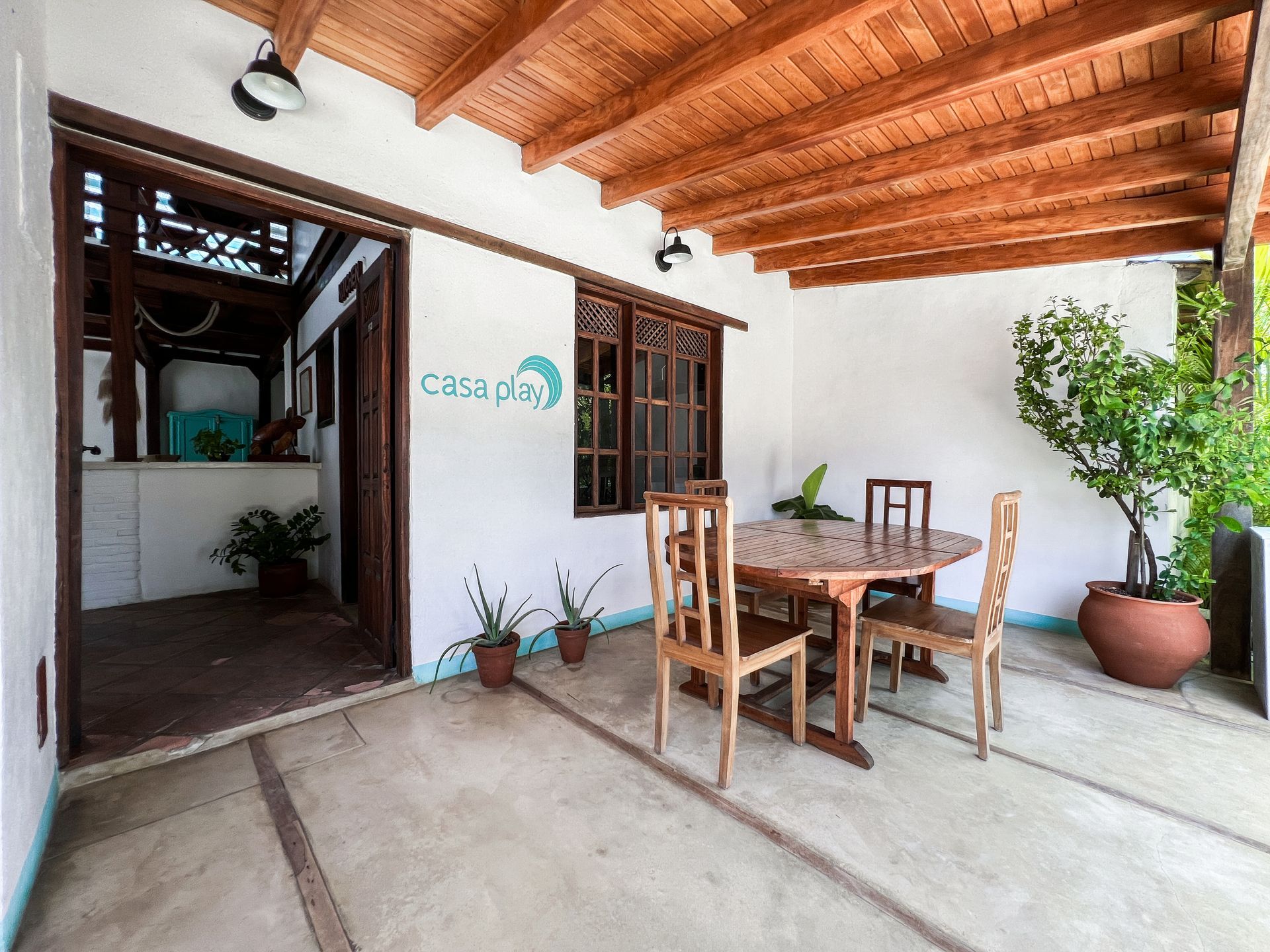 There is a table and chairs on the porch of a house.