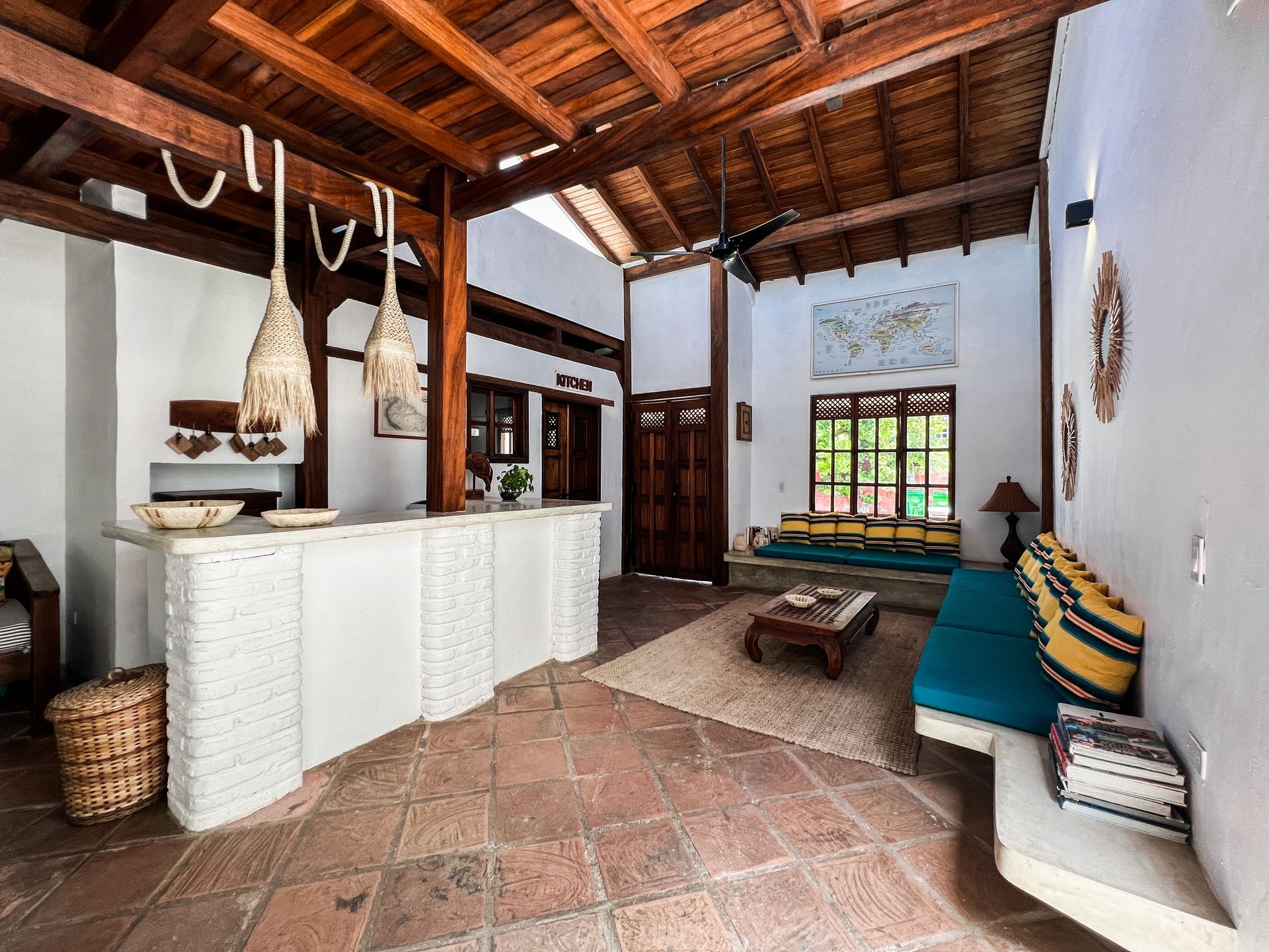 A living room with a wooden ceiling , a couch , a table and a counter.