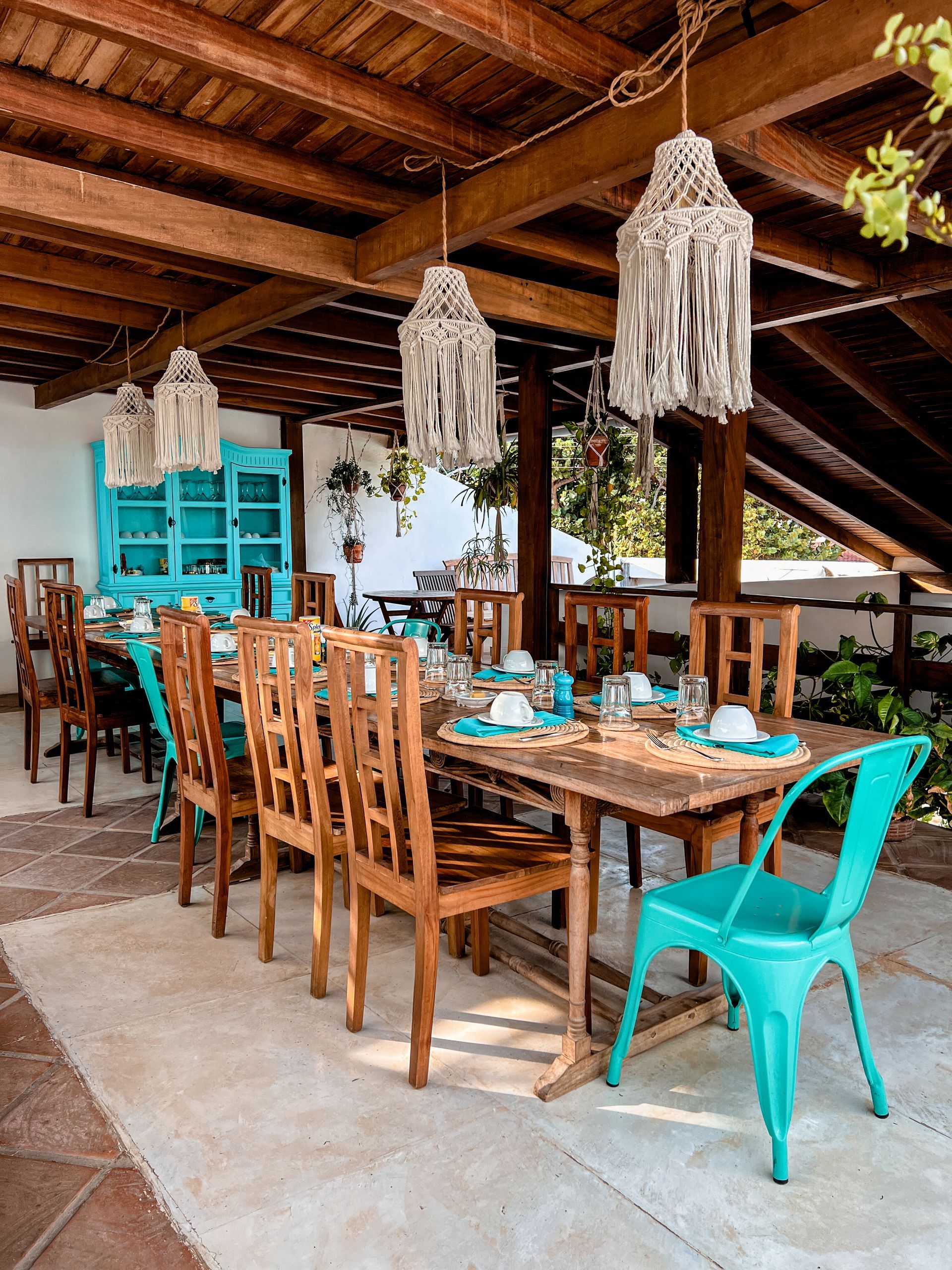 A dining room with a long wooden table and chairs.