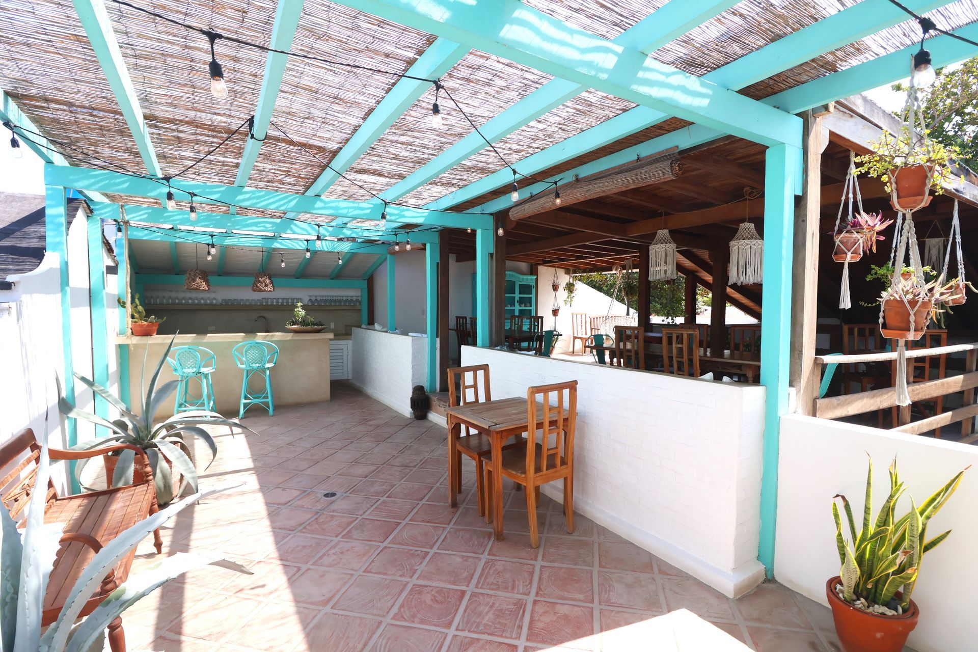 A patio with a table and chairs under a blue roof