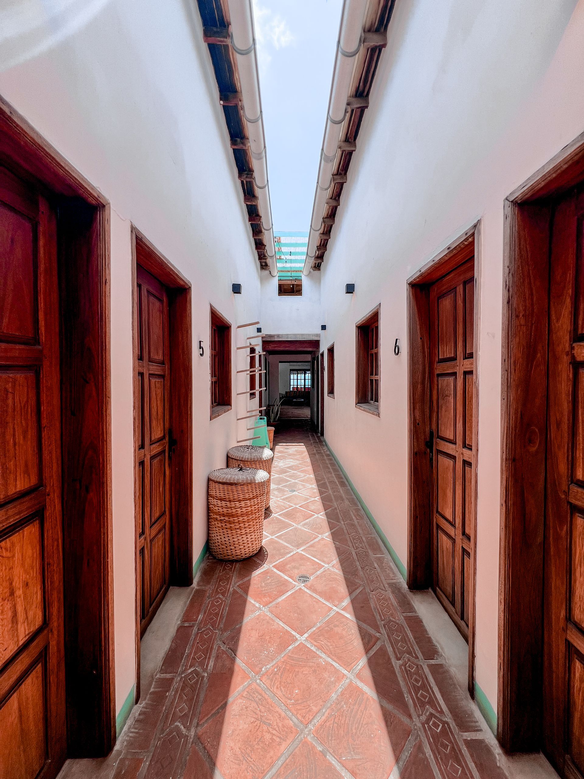 A long hallway between two buildings with wooden doors