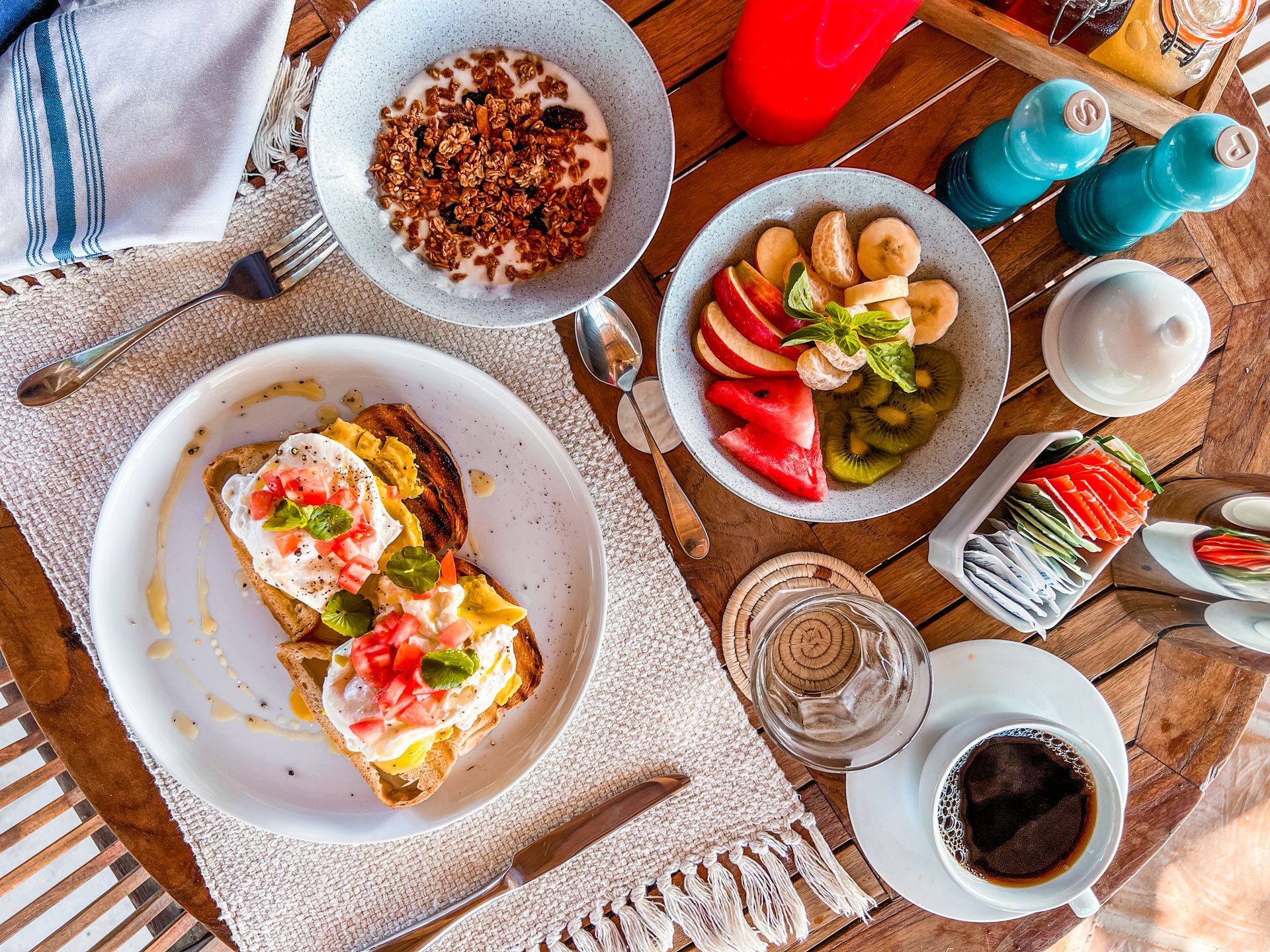 A table topped with plates of food and a cup of coffee.