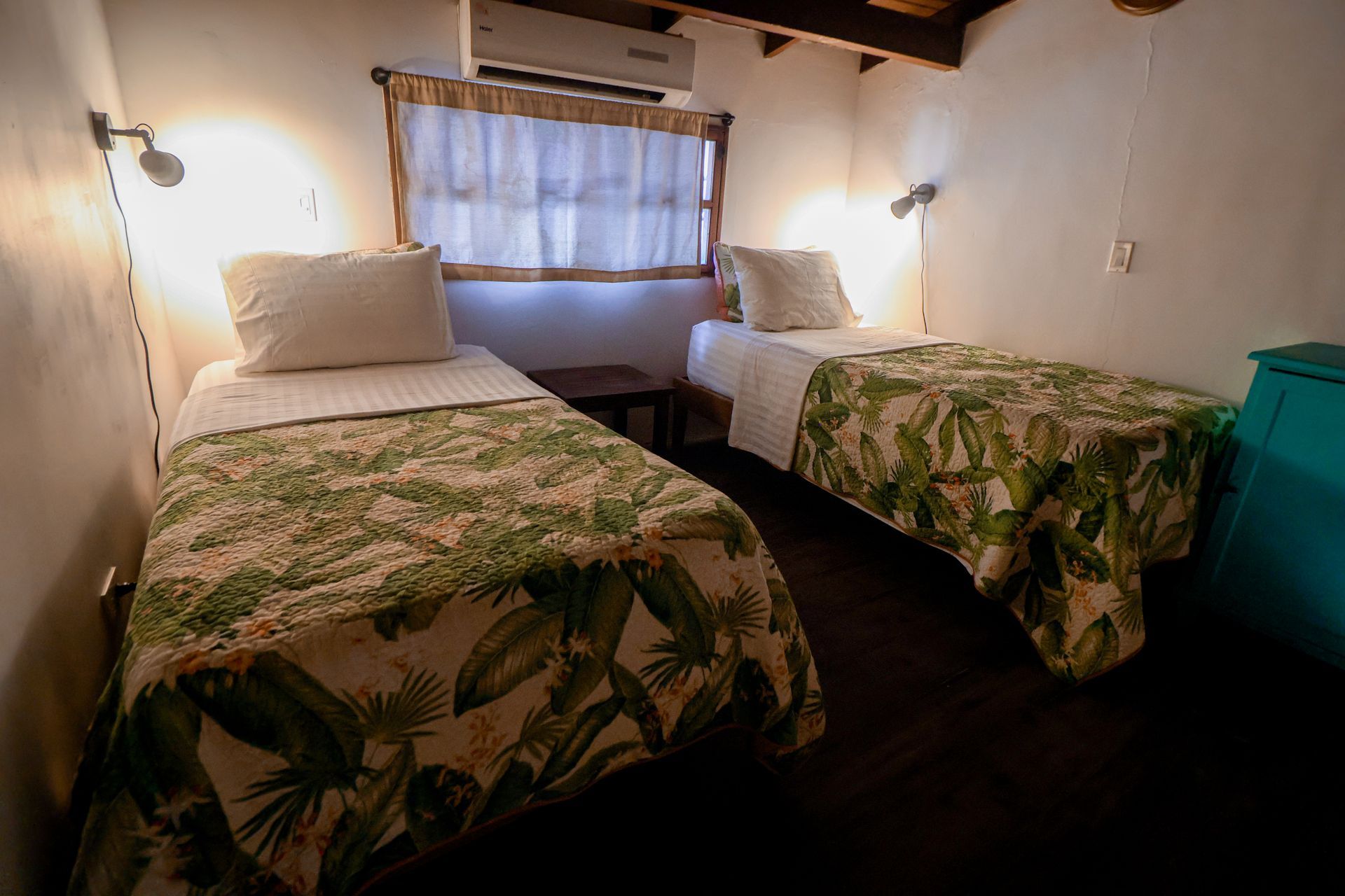 A bedroom with two twin beds and a window.