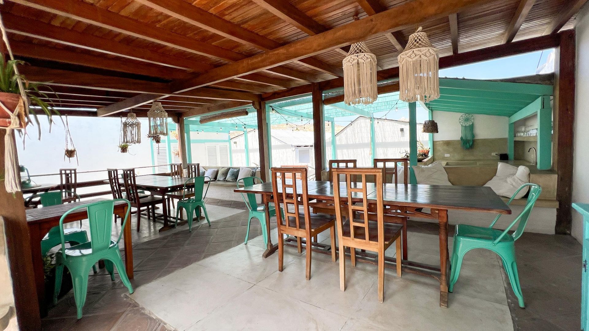 A large dining room with tables and chairs under a canopy.